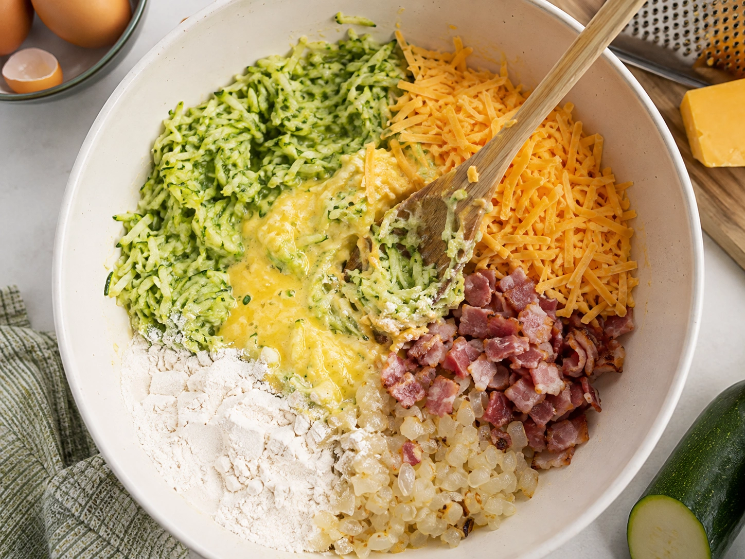 Mixing zucchini slice batter in a large bowl